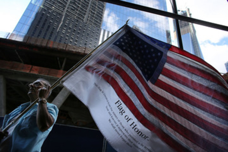 Un hombre ondea en la Zona Cerno una bandera de EEUU que contiene los nombres de todas las víctimas del 11S. (Spencer PLATT/AFP PHOTO)