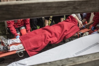 Uno de los heridos es retirado en camilla en la bajada del callejón. (Lander ARROYABE/ARGAZKI PRESS)