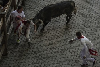 Un corredor escapa de un astado que se ha fijado en él. (Jagoba MANTEROLA/FOKU)