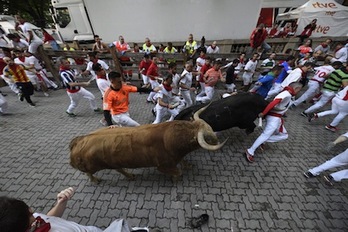 El toro Hechizo está a punto de empitonar a un corredor en el tramo del callejón. (Gorka RUBIO/FOKU)