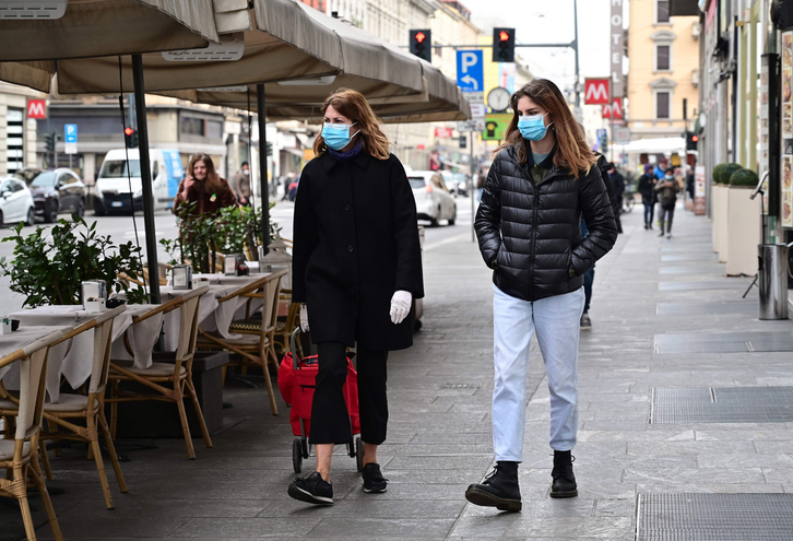 Bi pertsona maskarilekin Italiako kaleetan zehar. (Miguel MEDINA / AFP).