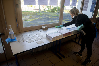 Una mujer en tareas de desinfección en un colegio electoral de Baiona. (Guillaume FAUVEAU)