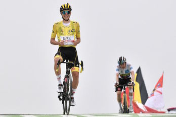 Tadej Pogacar muestra su maillot amarillo al ganar por delante de Vingegaard. (Philippe LOPEZ/AFP)