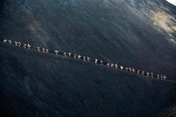 Turistas subiendo en grupo a la cima del volcán.