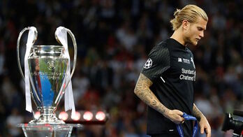 Karius, desafortunado protagonista de la última final entre Liverpool y Real Madrid, pasa cabizbajo por delante del trofeo.