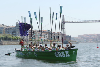 Hondarribiko arraunlariak, arraunak goian, Santurtziko banderako garaipena ospatzen, atzean Bizkaia zubia dutela.