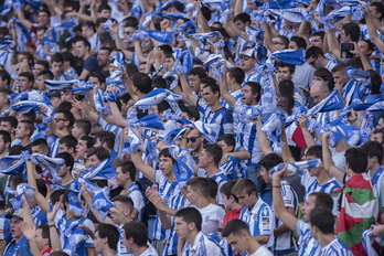 Aficionados de la Real animan a su equipo en un partido liguero frente al Barça, en Anoeta. 