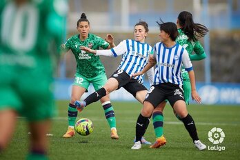Sanadri intenta proteger el balón ante Leire Baños.