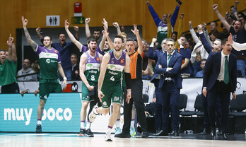 El banquillo de Unicaja celebra un triple de Kalinoski.
