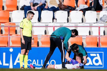 Imanol es atendido en la banda del Anxo Carro tras lesionarse.