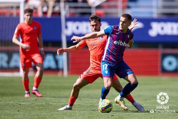 Corpas protege el balón, encimado por Pampín.