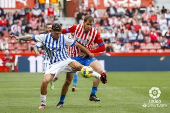Javi López trata de proteger el esférico ante un rival asturiano.