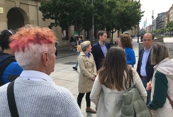 Un seguidor del PP observa a sus candidatos después de su intervención ante los medios.