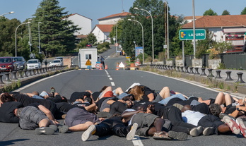 Irun eta Hendaia arteko zubian iazko uztailean egindako ekintza migranteen heriotzak salatzeko eta, atzean, Polizia frantsesaren kontrola.