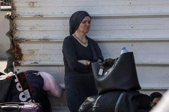 Una mujer palestina con pasaporte extranjero espera en la puerta de Rafah con la esperanza de cruzar a Egipto mientras continúan los ataques de Israel contra la Franja de Gaza.