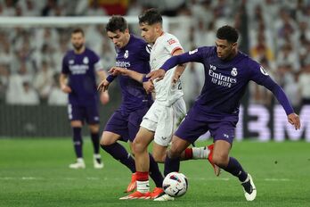 Beñat Prados trata de proteger el esférico ante la presión de Brahim y Bellingham.