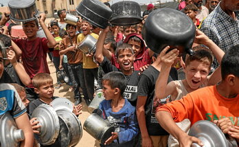 Niños palestinos hacen cola en un reparto de comida en Rafah.