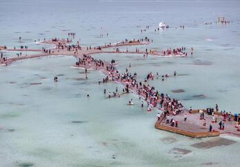 Cientos de personas caminan por las pasarelas sobre el lago.