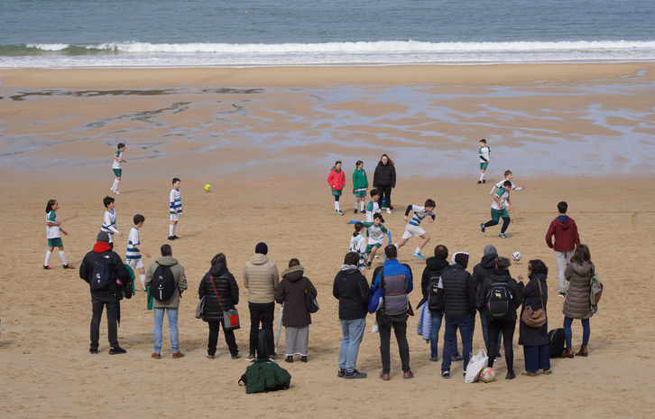 Eskola kiroleko futbol partidak hondartzan.